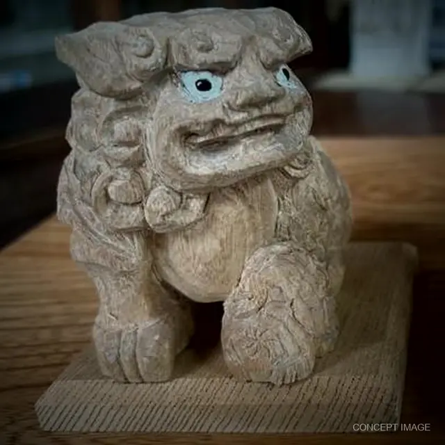 A carved wooden shishi on a small base