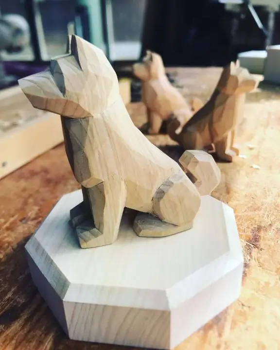 A faceted dog carved in the round on an octagonal base