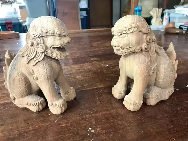 A pair of seated shishi in natural wood